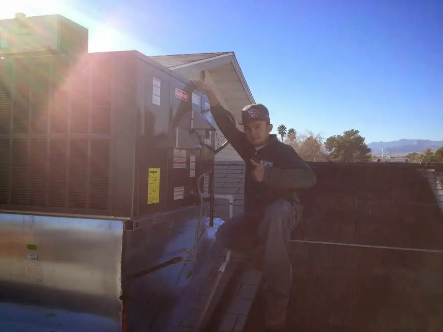 HVAC technician performing Heat Pump Repair on a rooftop unit in Pewaukee